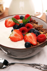 Tasty homemade granola served on table. Healthy breakfast with a bowl of oatmeal with banana, blueberries, strawberries and healthy food for Breakfast