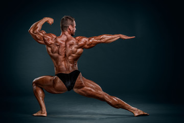 Obraz premium Bodybuilding Competitor Posing and Flexing Muscles