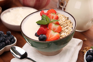 Tasty homemade granola served on table. Healthy breakfast with a bowl of oatmeal with banana, blueberries, strawberries and healthy food for Breakfast