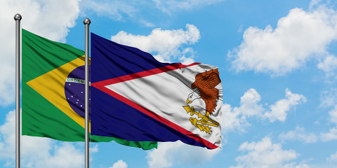 Brazil and American Samoa flag waving in the wind against white cloudy blue sky together. Diplomacy...