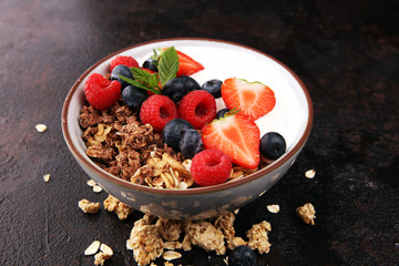 Tasty homemade granola served on table. Healthy breakfast with a bowl of oatmeal with banana, blueberries, strawberries and healthy food for Breakfast