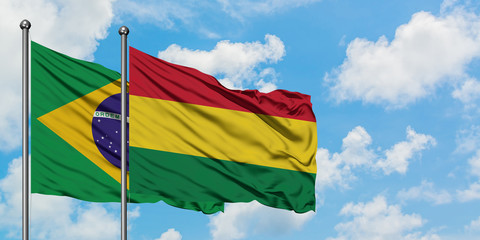 Brazil and Bolivia flag waving in the wind against white cloudy blue sky together. Diplomacy concept, international relations.