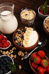 Tasty homemade granola served on table. Healthy breakfast with a bowl of oatmeal with banana, blueberries, strawberries and healthy food for Breakfast