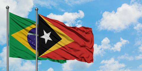 Brazil and East Timor flag waving in the wind against white cloudy blue sky together. Diplomacy concept, international relations.