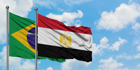 Brazil and Egypt flag waving in the wind against white cloudy blue sky together. Diplomacy concept, international relations.