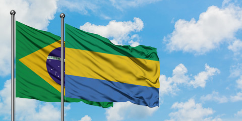 Brazil and Gabon flag waving in the wind against white cloudy blue sky together. Diplomacy concept, international relations.