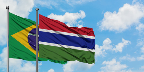 Brazil and Gambia flag waving in the wind against white cloudy blue sky together. Diplomacy concept, international relations.