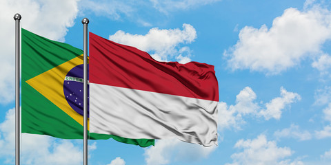 Brazil and Indonesia flag waving in the wind against white cloudy blue sky together. Diplomacy concept, international relations.