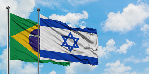 Brazil and Israel flag waving in the wind against white cloudy blue sky together. Diplomacy concept, international relations.