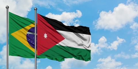 Brazil and Jordan flag waving in the wind against white cloudy blue sky together. Diplomacy concept, international relations.