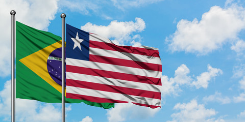 Brazil and Liberia flag waving in the wind against white cloudy blue sky together. Diplomacy concept, international relations.