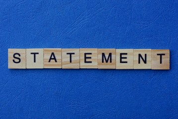 word statement made from brown wooden letters on a blue table