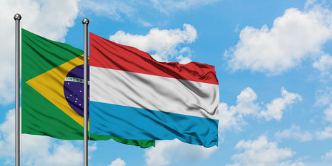 Brazil and Luxembourg flag waving in the wind against white cloudy blue sky together. Diplomacy concept, international relations.