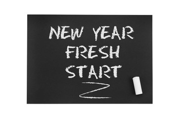Inscription in chalk on black paper: New year, fresh start. The concept of life from scratch, a new period in life, renewal, fresh solutions, new beginnings and opportunities.