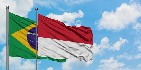 Brazil and Monaco flag waving in the wind against white cloudy blue sky together. Diplomacy concept, international relations.