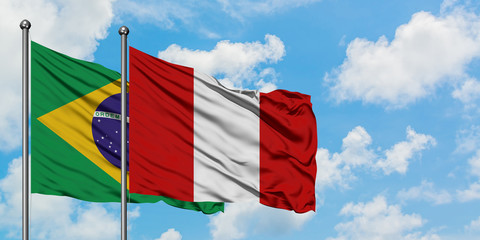 Brazil and Peru flag waving in the wind against white cloudy blue sky together. Diplomacy concept, international relations.