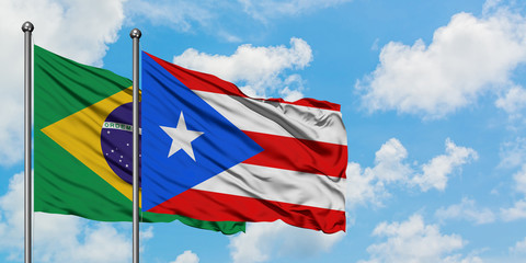 Brazil and Puerto Rico flag waving in the wind against white cloudy blue sky together. Diplomacy concept, international relations.