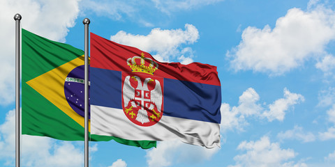 Brazil and Serbia flag waving in the wind against white cloudy blue sky together. Diplomacy concept, international relations.