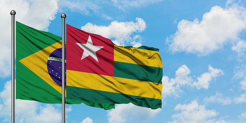 Brazil and Togo flag waving in the wind against white cloudy blue sky together. Diplomacy concept, international relations.