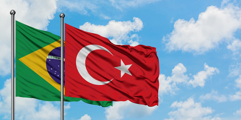 Brazil and Turkey flag waving in the wind against white cloudy blue sky together. Diplomacy concept, international relations.