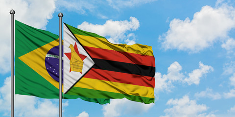 Brazil and Zimbabwe flag waving in the wind against white cloudy blue sky together. Diplomacy concept, international relations.