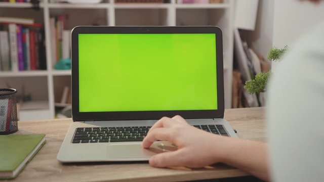 Young hands man use laptop computer with green screen chroma key display internet business office technology work desk connection keyboard pc device slow motion