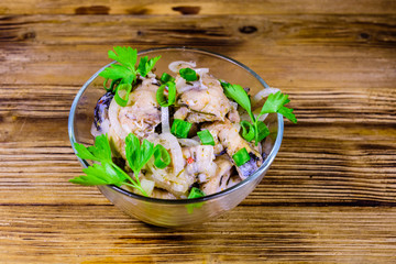 Pieces of the marinated carp fish in glass bowl on wooden table