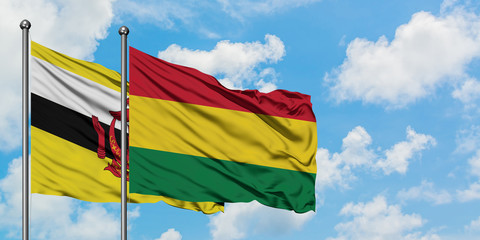 Brunei and Bolivia flag waving in the wind against white cloudy blue sky together. Diplomacy concept, international relations.