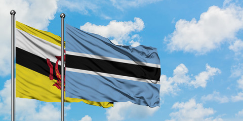 Brunei and Botswana flag waving in the wind against white cloudy blue sky together. Diplomacy concept, international relations.
