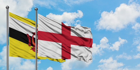 Brunei and England flag waving in the wind against white cloudy blue sky together. Diplomacy concept, international relations.