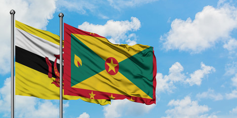 Brunei and Grenada flag waving in the wind against white cloudy blue sky together. Diplomacy concept, international relations.