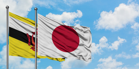 Brunei and Japan flag waving in the wind against white cloudy blue sky together. Diplomacy concept, international relations.