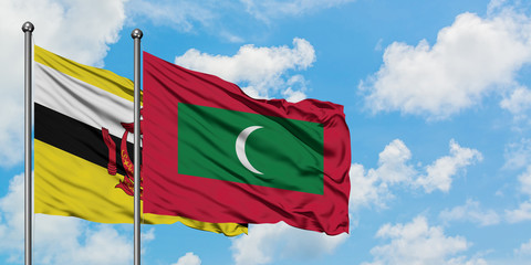 Brunei and Maldives flag waving in the wind against white cloudy blue sky together. Diplomacy concept, international relations.