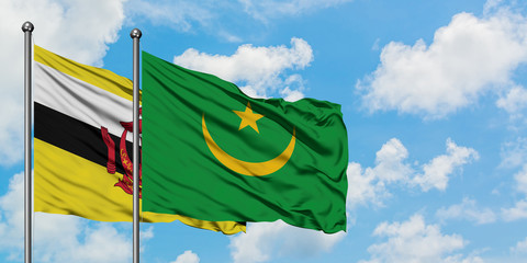 Brunei and Mauritania flag waving in the wind against white cloudy blue sky together. Diplomacy concept, international relations.