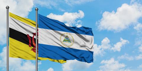 Brunei and Nicaragua flag waving in the wind against white cloudy blue sky together. Diplomacy concept, international relations.