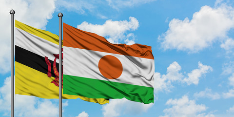 Brunei and Niger flag waving in the wind against white cloudy blue sky together. Diplomacy concept, international relations.