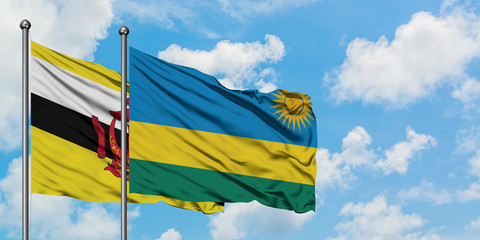 Brunei and Rwanda flag waving in the wind against white cloudy blue sky together. Diplomacy concept, international relations.
