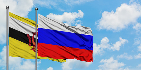 Brunei and Russia flag waving in the wind against white cloudy blue sky together. Diplomacy concept, international relations.