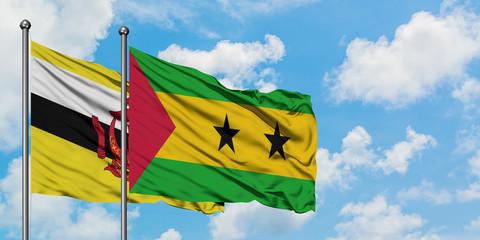 Brunei and Sao Tome And Principe flag waving in the wind against white cloudy blue sky together. Diplomacy concept, international relations.