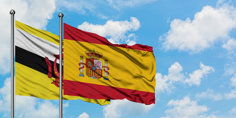 Brunei and Spain flag waving in the wind against white cloudy blue sky together. Diplomacy concept, international relations.
