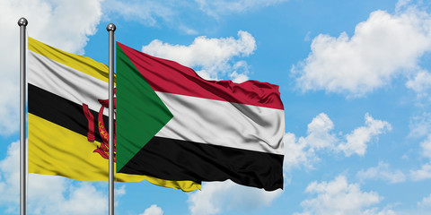 Brunei and Sudan flag waving in the wind against white cloudy blue sky together. Diplomacy concept, international relations.
