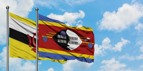 Brunei and Swaziland flag waving in the wind against white cloudy blue sky together. Diplomacy concept, international relations.