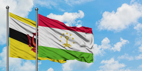 Brunei and Tajikistan flag waving in the wind against white cloudy blue sky together. Diplomacy concept, international relations.