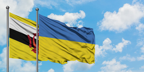 Brunei and Ukraine flag waving in the wind against white cloudy blue sky together. Diplomacy concept, international relations.