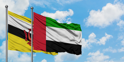 Brunei and United Arab Emirates flag waving in the wind against white cloudy blue sky together. Diplomacy concept, international relations.