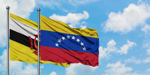 Brunei and Venezuela flag waving in the wind against white cloudy blue sky together. Diplomacy concept, international relations.