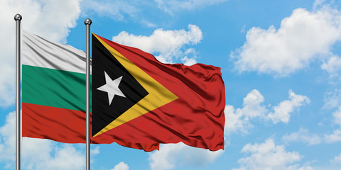Bulgaria and East Timor flag waving in the wind against white cloudy blue sky together. Diplomacy concept, international relations.