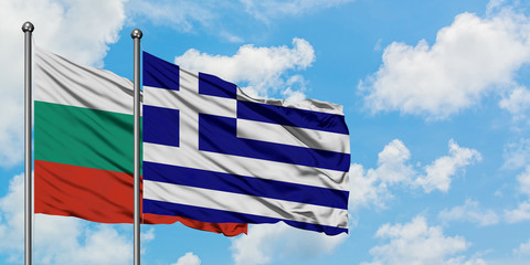 Bulgaria and Greece flag waving in the wind against white cloudy blue sky together. Diplomacy concept, international relations.