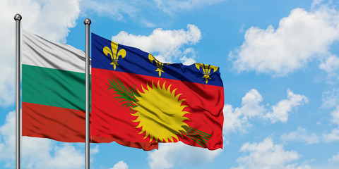 Bulgaria and Guadeloupe flag waving in the wind against white cloudy blue sky together. Diplomacy concept, international relations.