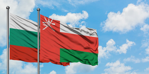 Bulgaria and Oman flag waving in the wind against white cloudy blue sky together. Diplomacy concept, international relations.